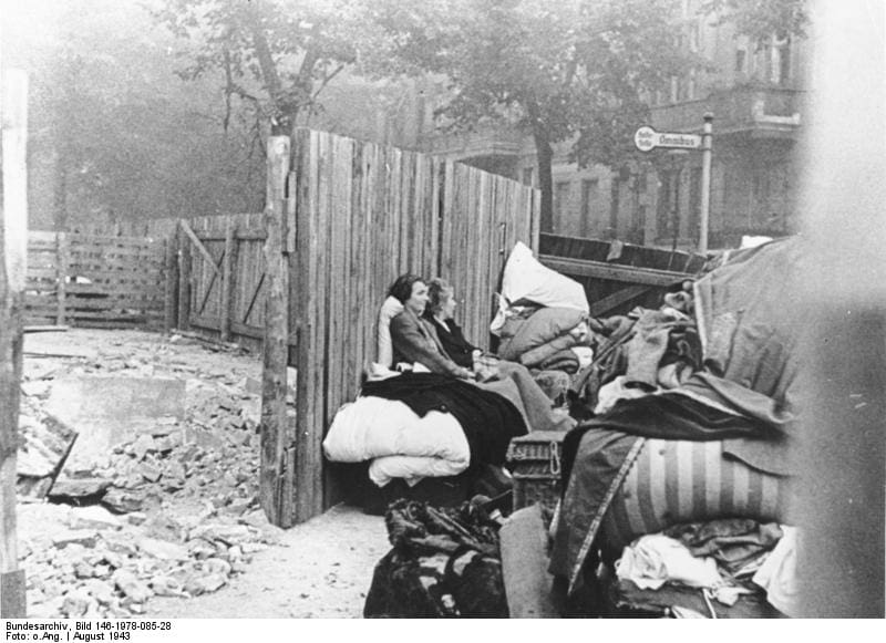 August 1943. Berlin.- Am Morgen nach dem britischen Bombenangriff (23./24.8.1943). Inmitten ihrer geretteten Habe haben die beiden Frauen Platz genommen und warten auf den Abtransport. Ausgebombte nach britischem Luftangriff. Bundesarchiv, Bild 146-1978-085-28 / CC-BY-SA 3.0, CC BY-SA 3.0 DE , via Wikimedia Commons